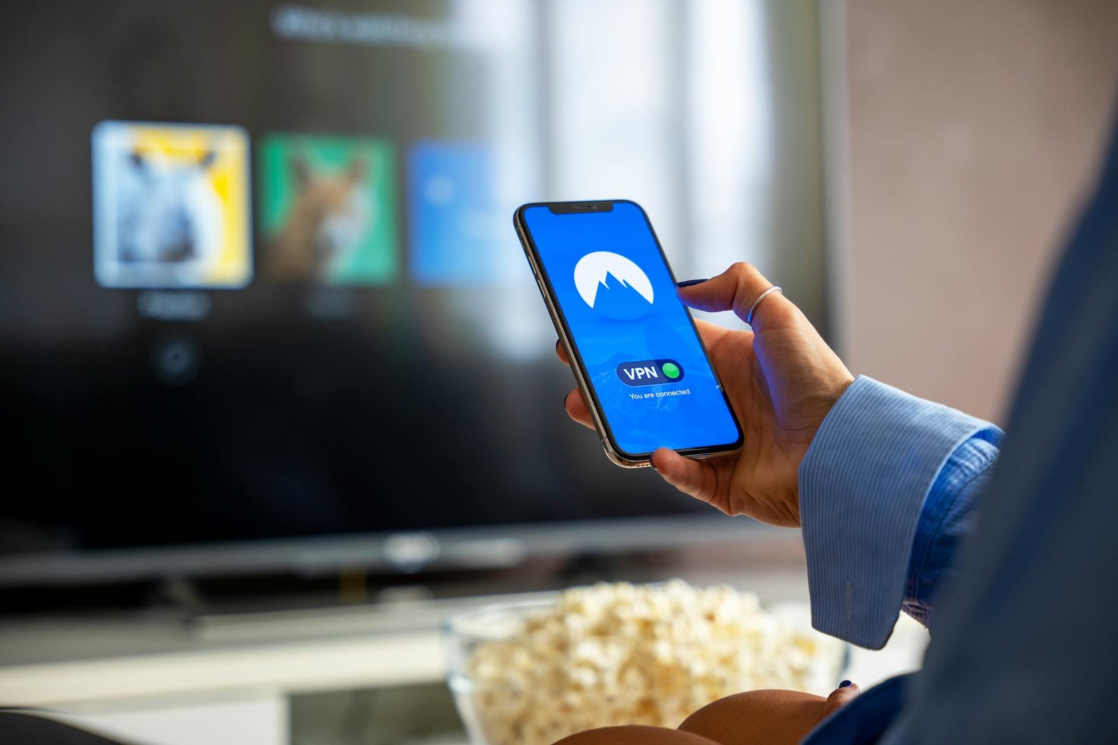 Best IPTV Subscriptions in 2026 — Smartphone in hand with smart TV streaming in the background | OTT-TV