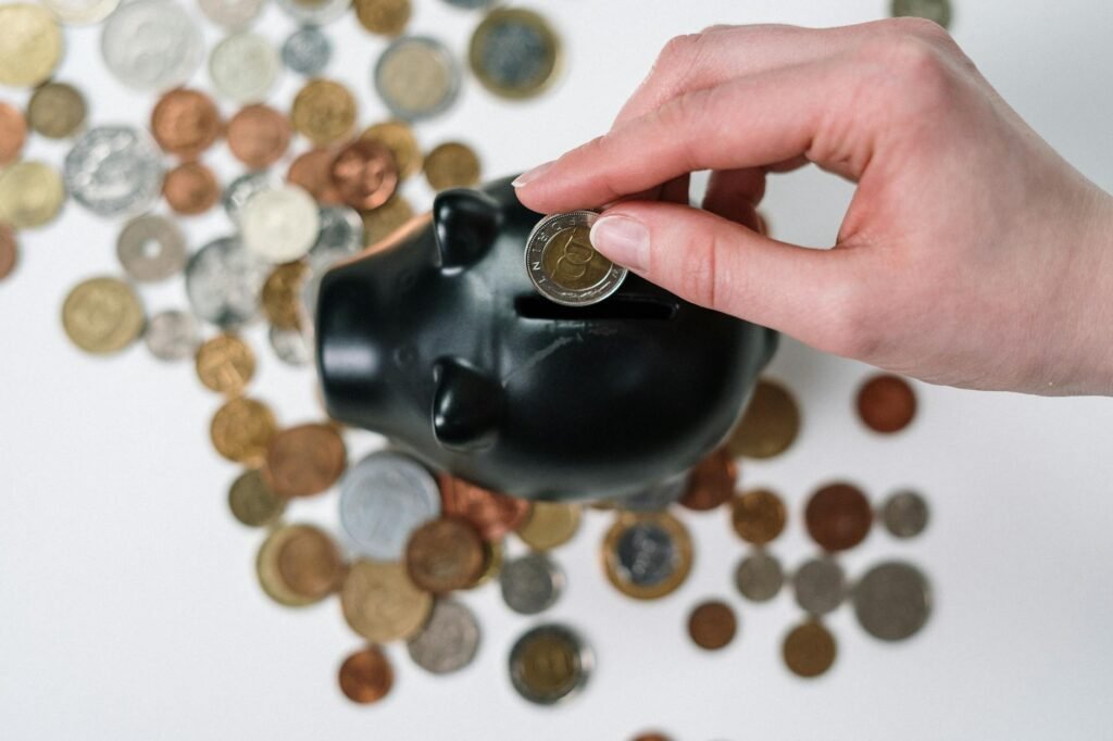 Cheap IPTV Service — Hand inserting a coin into a piggy bank, conveying budget savings | OTT-TV