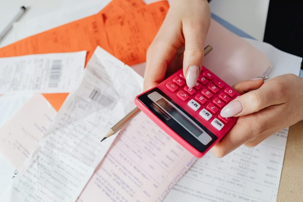 IPTV Pricing Guide 2026 — Hands using a calculator with bills and receipts on a desk | OTT-TV